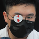 A secondary student covers one eye reading "Hong Kong" in memory of a woman injured in an earlier pro-democracy protest in Hong Kong, on Monday, Sept. 2, 2019.